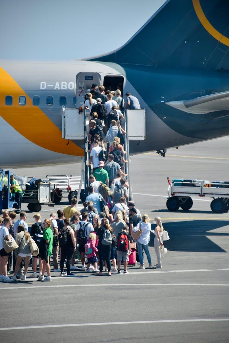 A long queue of tourists line up to board a plane  