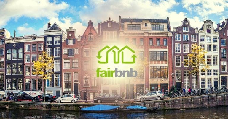 An image for the company Fairbnb, showing a canal in amsterdam with classic red and white houses in the background, with the text "fairbnb" in green and grey lettering under green lines forming houses above the text.